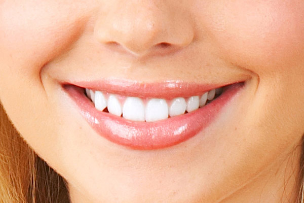 Imagen de la parte inferior del rostro de una mujer con labios suaves y una sonrisa cuidada, destacando los beneficios de acudir a un dentista en Granada centro.