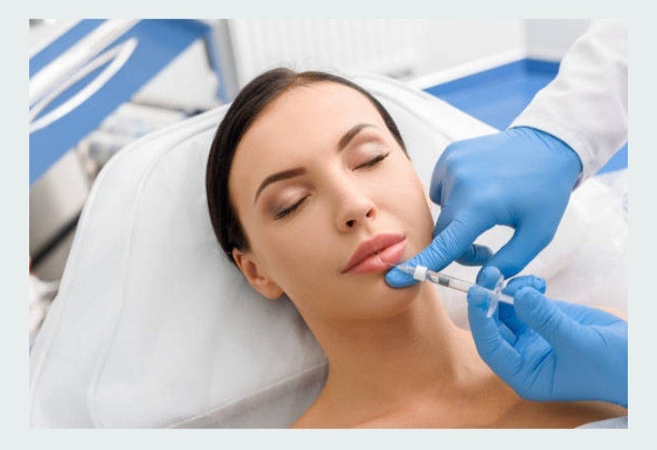 Dentista con guantes azules aplicando un procedimiento estético, representando la precisión y profesionalidad en clínicas dentales de Granada centro.