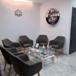 Área de espera con sillas modernas y decoración minimalista, destacando el confort y diseño ofrecidos por un dentista en Granada centro.
