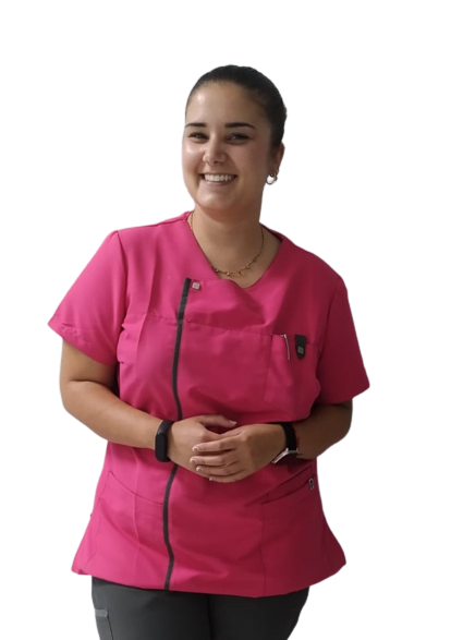 Dentista con uniforme rosa y postura relajada, representando la profesionalidad y dedicación en los servicios ofrecidos en Granada centro.
