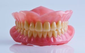 Modelo de prótesis dental superior e inferior con dientes naturales, mostrando soluciones avanzadas para pacientes en clínicas dentales de Granada centro.