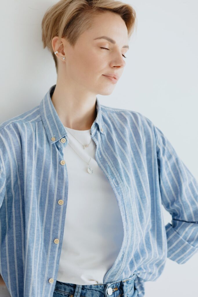 Persona relajada y sonriente, con camisa a rayas, representando confianza y bienestar emocional tras recibir implantes dentales, resaltando sus beneficios psicológicos.