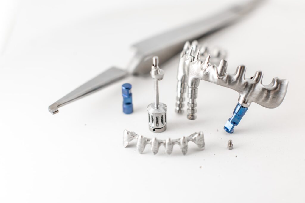 Imagen de componentes metálicos y herramientas de precisión necesarias para implantes dentales, destacando detalles relacionados con los aspectos económicos de los implantes dentales.