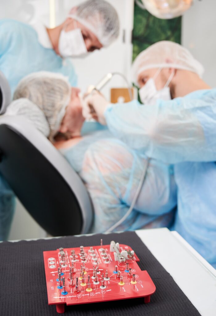 Equipo quirúrgico dental especializado, incluyendo kit de implantes sobre mesa de trabajo, en una clínica odontológica donde se realizan procedimientos relacionados con preguntas frecuentes sobre la garantía de los implantes dentales.