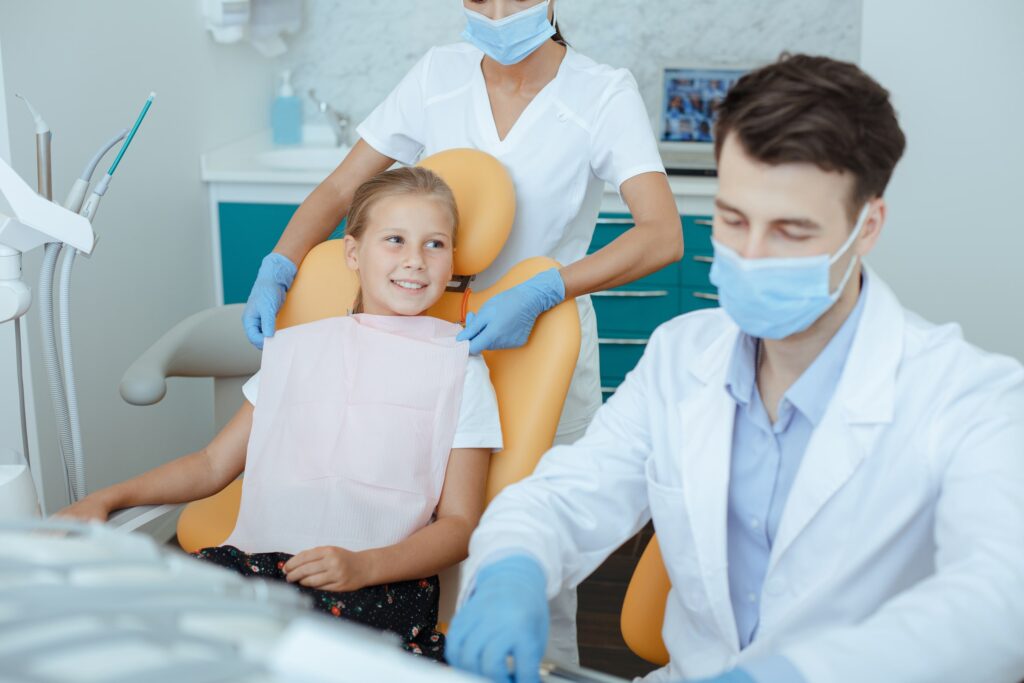 Equipo dental realizando el diagnóstico y planificación del tratamiento a una paciente infantil en una consulta odontológica, con enfoque en la evaluación ortodóncica profesional.