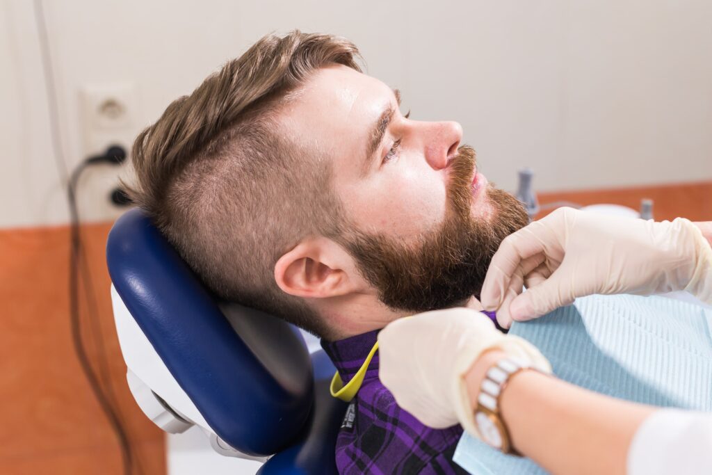 Paciente en una clínica dental recibiendo atención profesional, ilustrando los factores que influyen en el precio del recontorneado dental en Granada, como la experiencia del dentista, la tecnología utilizada y la complejidad del tratamiento.