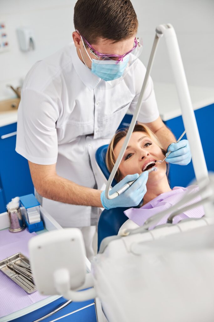 Odontólogo realizando una cirugía oral en una paciente, ejemplificando la importancia de seguir recomendaciones específicas para casos de muelas del juicio y procedimientos de cirugía oral, clave para una recuperación segura y efectiva.