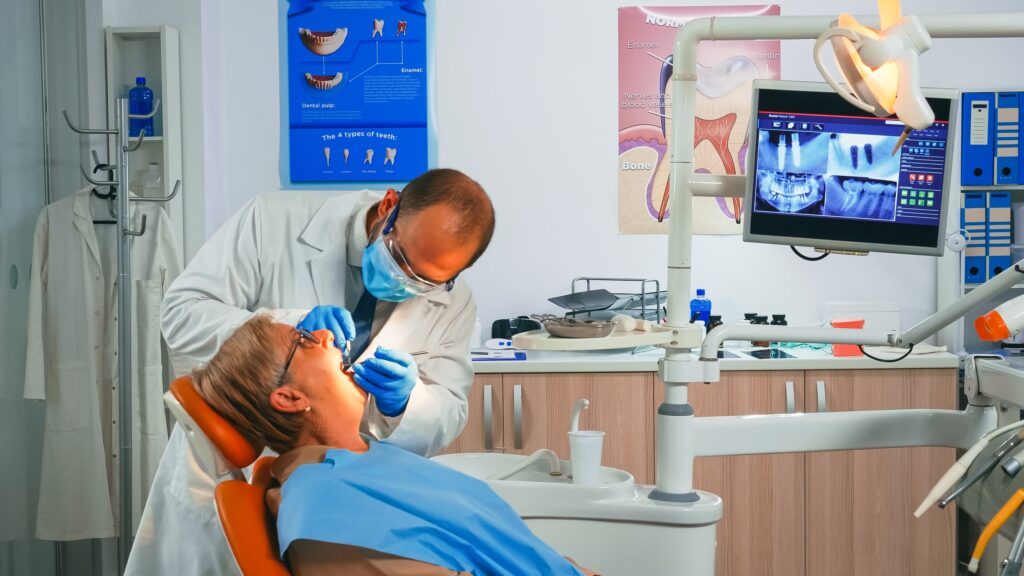 Dentista revisando la colocación de una nueva corona dental en una paciente, destacando el impacto positivo de las coronas dentales en la salud bucal general y la función de los dientes restaurados.