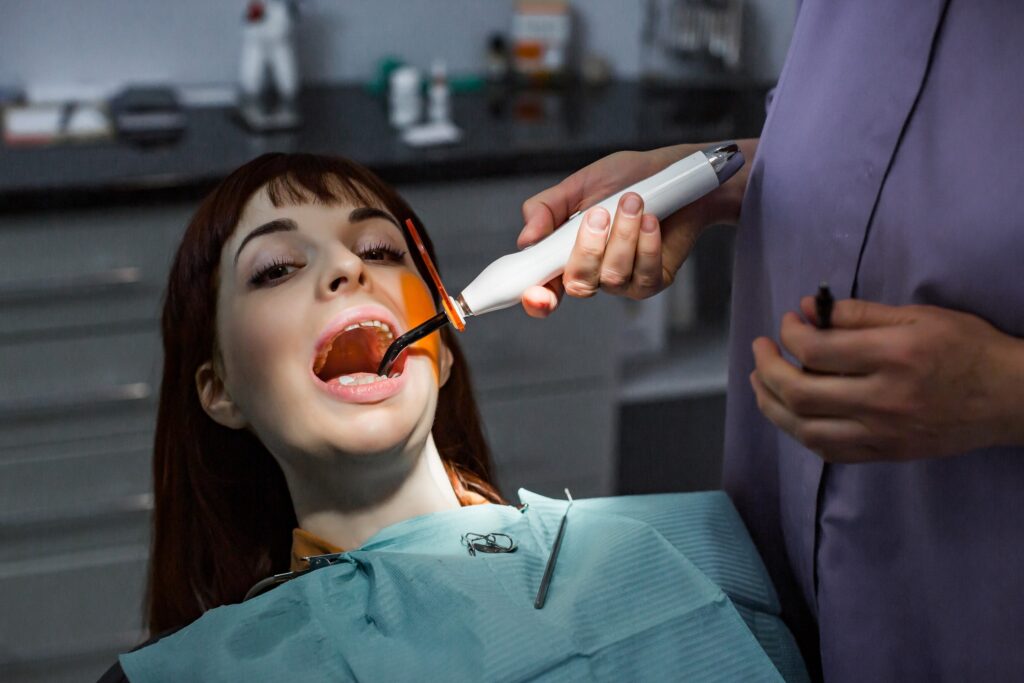 Dentista realiza revisión a una paciente durante la planificación del tratamiento con Invisalign, preparando un diagnóstico preciso y personalizado para alinear los dientes de manera invisible.