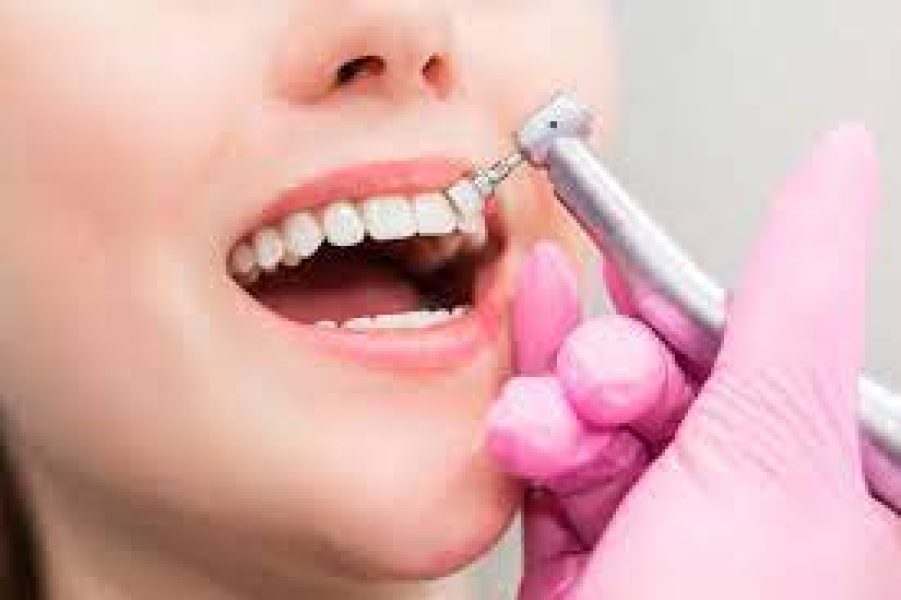 limpieza Mano enguantada de rosa utilizando un espejo dental para inspeccionar la cavidad bucal, representando la precisión y cuidado de un dentista en Granada centro.